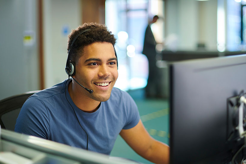 Male Customer Service Representative answers customer call on headset.