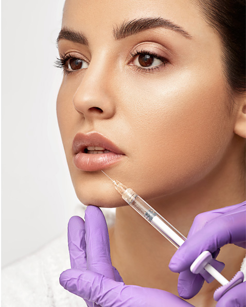 Woman getting a medical cosmetic injection in her lips.